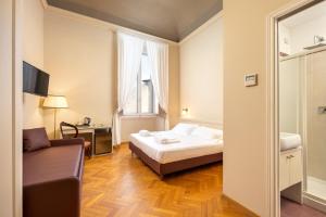 - une chambre avec un lit et un canapé dans l'établissement L'Antica Porta Boutique B&B, à Florence