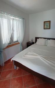 um quarto com uma grande cama branca e uma janela em Apartments Maxim em Tivat