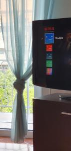 uma televisão ao lado de uma janela com uma cortina em Apartments Maxim em Tivat