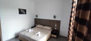 a bedroom with a bed with two towels on it at Aleks Holiday Rooms in Ksamil +5 photos