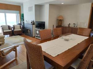 - une salle à manger avec une table et des chaises en bois dans l'établissement Furadouro Pool&Beach Apart, à Ovar
