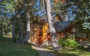 a log cabin with trees in front of it at Cabañas Lelikelen in Villa La Angostura