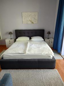 a large bed in a bedroom with two night stands at APP Leo in Rab