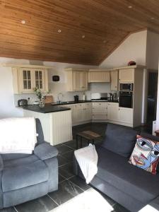 uma cozinha com dois sofás e uma mesa num quarto em Cheerful 2 bedroom cottage with free parking em Droíchead an Chláir