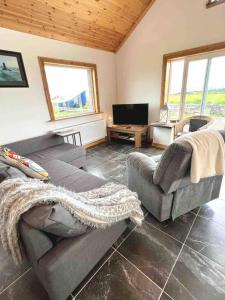 uma sala de estar com dois sofás e uma televisão em Cheerful 2 bedroom cottage with free parking em Droíchead an Chláir