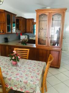 uma cozinha com uma mesa com flores em HCeas Villa Compound is 5 minutes from the airport and beaches, can sleep up to 30 ppl em Bon Accord