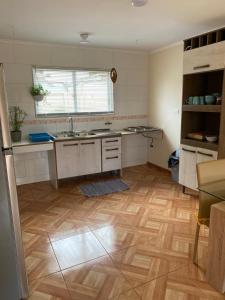 cocina con suelo de madera y fregadero en Casa para 4 personas, en El Quisco Norte, en El Quisco