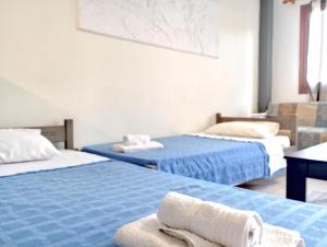 a room with two beds with towels on them at Rodi Apartments 1 in Kamari
