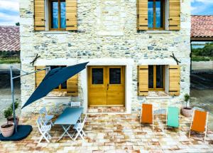 een huis met een patio met stoelen en een houten deur bij Grand gite "le Mas de la FANGOUZE" Aigues Mortes in Aigues-Mortes