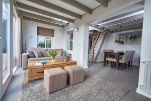 a living room with a couch and a table at Villa Magnolia in Oostkapelle