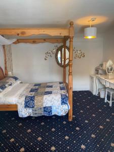 a bedroom with a bed with a wooden canopy at Craighlaw Arms Boutique B&B in Kirkcowan
