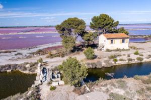 una casa vieja en una isla en el agua en MAS de COLOMINA Aigues-Mortes en Aigues-Mortes