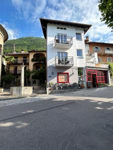 ein weißes Gebäude an der Straßenseite in der Unterkunft Boutique Centrale in Brione sopra Minusio