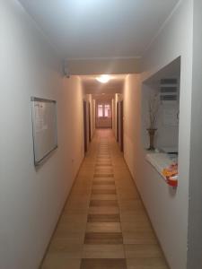un corridoio che conduce a una camera con pareti bianche e pavimenti in legno di Pariska Noć a Loznica