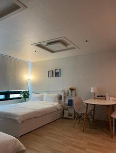 - une chambre avec un lit et une table dans l'établissement If House Hongdae, à Séoul