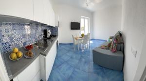 a kitchen and a living room with a blue tile floor at Bellessere in vacanza Forio d’ Ischia in Forio d'Ischia