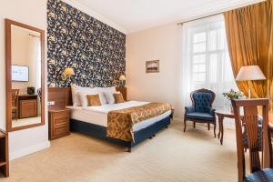 um quarto de hotel com uma cama e uma cadeira em Hotel Katerina em Znojmo