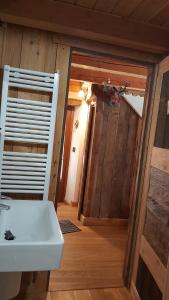 ein Badezimmer mit einem weißen Waschbecken und einer Holzwand in der Unterkunft Il canto del bosco in Valpelline