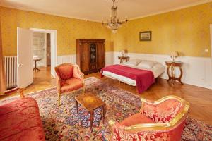 a bedroom with a bed and a couch and chairs at Chateau de la Marjolaine in Essômes-sur-Marne