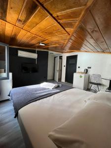 イスタンブールにあるNest HOTEL Sisliの木製の天井のベッドルーム1室(大型ベッド1台付)