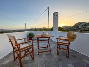 una mesa y 2 sillas en un balcón con vistas a la puesta de sol en Casa Livadia, en Zefiría