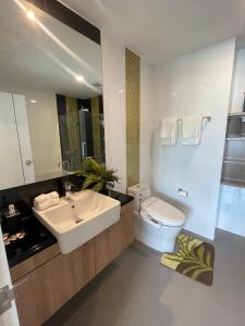 een badkamer met een wastafel, een toilet en een spiegel bij Seaview condo in Siracha (Free onzen) in Si Racha