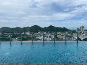a swimming pool with a city in the background at Seaview condo in Siracha (Free onzen) in Si Racha