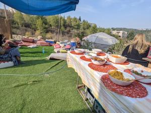 a table with bowls of food sitting on the grass at guest house אשראם בכרמל - אכסניה in Dāliyat el Karmil
