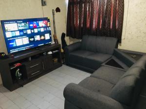 sala de estar con sofá y TV en Alojamiento en Cholula, en Cholula