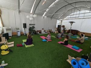 a group of people sitting in a tent doing yoga at guest house אשראם בכרמל - אכסניה in Dāliyat el Karmil