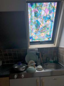 a kitchen with a sink and a stained glass window at Hazelcroft Guest House in London