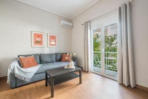 - un salon avec un canapé bleu et une table dans l'établissement Comfortable Apartment In Athens, à Athènes