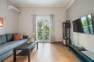 uma sala de estar com um sofá e uma televisão em Comfortable Apartment In Athens em Atenas