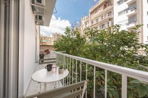 d'un balcon avec une table blanche et une table. dans l'établissement Comfortable Apartment In Athens, à Athènes