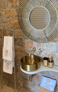 a bathroom sink with a mirror and a fan at Oikos Sani Suites in Sani Beach