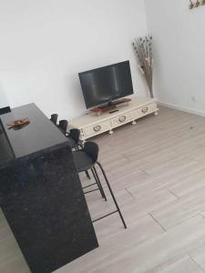 een woonkamer met een televisie en een tafel en stoelen bij Refúgio Na Parreira in Portel