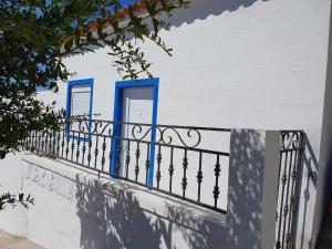 een balkon met blauwe deuren en een hek bij Refúgio Na Parreira in Portel