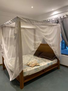 a bed with a canopy in a room at Ripasso Apartments in Malindi