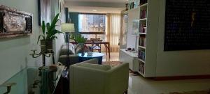 Apartamento na Praia dos Milionários في ايليوس: غرفة معيشة مع كرسي وطاولة