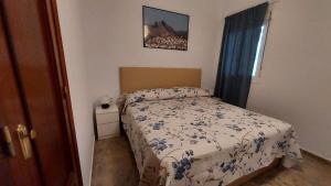 a small bedroom with a bed and a window at Piso en el Centro de Antequera in Antequera
