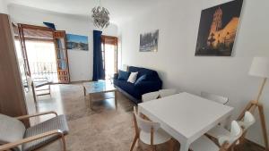 a living room with a table and a blue couch at Piso en el Centro de Antequera in Antequera