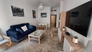 a living room with a blue couch and a table at Piso en el Centro de Antequera in Antequera