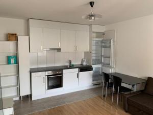 a kitchen with white cabinets and a table and chairs at Beautiful Apartment in Center of Küblis in Küblis