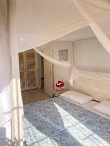 a bedroom with a large white bed with a canopy at Ripasso Apartments in Malindi