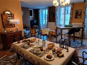 een woonkamer met een tafel met eten erop bij UN AIR MOULINOIS in Moulins