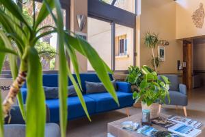 un sofá azul en una sala de estar con plantas en Hotel & Restaurant San Pellegrino, en Folelli