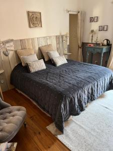 een slaapkamer met een groot bed en een zwart dekbed bij Le Paillé de Torreilles in Torreilles
