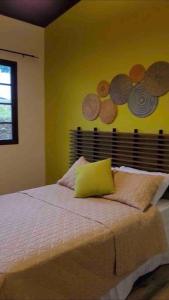 1 dormitorio con 1 cama con monedas en la pared en Noelle’s House - Alto Boquete, a natural place to enjoy., en Alto Boquete
