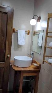y baño con lavabo blanco y espejo. en Noelle’s House - Alto Boquete, a natural place to enjoy., en Alto Boquete
