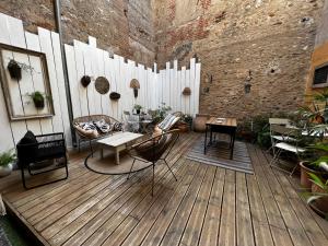 un patio con sillas, mesas y una pared de ladrillo en Le Paillé de Torreilles, en Torreilles